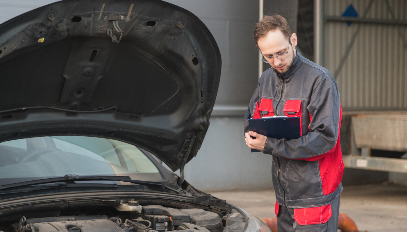 Pictured is a mechanic inspecting a car.